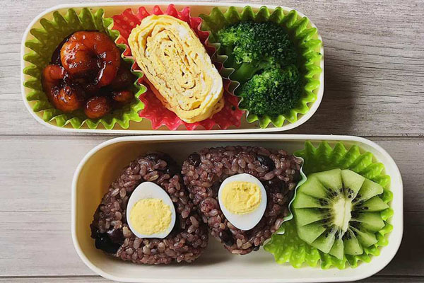 Tôm sốt teriyaki, trứng cuộn, cơm đậu đen trang trí với trứng luộc, kiwi.