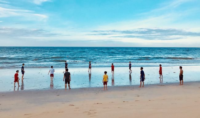 Trẻ 13, 14 tuổi chơi bóng đá bãi biển cùng với người lớn. Các em cũng dàn đội hình, cúi chào khán giả một cách bài bản trước khi “vào trận”