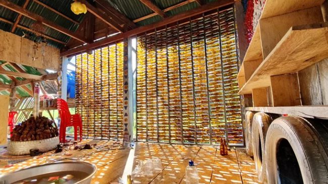 Vách tường của quán được làm từ hàng trăm vỏ chai. Một số trang trí được thiết kế từ những chiếc lá khô chủ quán lấy trong rừng.