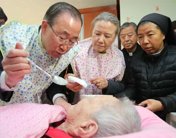 Cựu tổng thư ký LHQ Ban Ki-moon bón thức ăn cho một người phụ nữ lớn tuổi tại một cơ sở phúc lợi xã hội ở Eumseong, Hàn Quốc. Ảnh: Reuter.