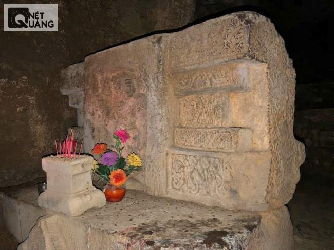 Bàn thờ Chăm trong động Tàng Chơn. Phía sau bàn thờ là một cái hang tối âm u càng khiến không gian nơi đây thêm kỳ bí.