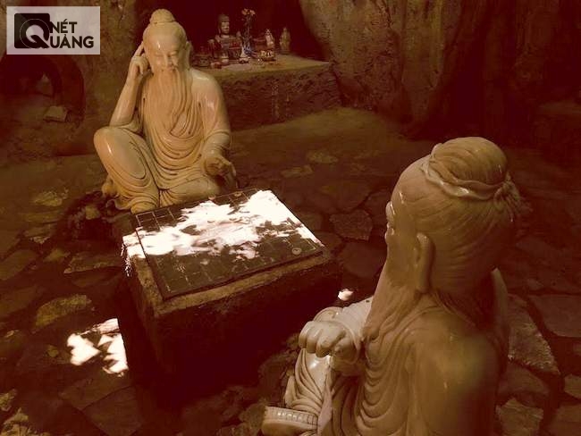 Nhị vị tiên đánh cờ trong Động Bàn Cờ, với ánh sáng là nắng trên trần động soi xuống bàn cờ tiên.
