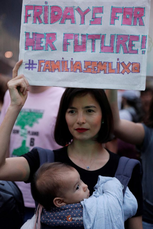 Người mẹ ở Brazil này đưa luôn con gái đi biểu tình kèm theo thông điệp hãy nghĩ cho tương lai của con cô và nhiều đứa trẻ khác - Ảnh: REUTERS