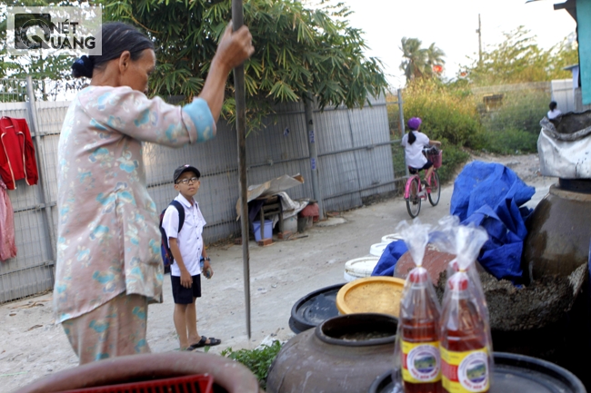 Cậu bé của làng đi học về,tò mò nhìn bà Lự, một trong những người làm nước mắm cao tuổi nhất làng đang thử độ mắm. Không ai chắc rằng thế hệ mới của làng sẽ tiếp nối nghề cha ông.