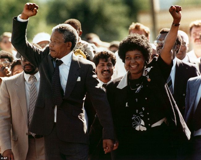 Nelson Mandela (trái) và vợ Winnie bước ra khỏi nhà tù Victor Verster ở Paarl, gần Cape Town, Nam Phi, sau khi ông ở tù 27 năm. Ảnh: AP.