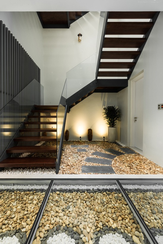 Hệ cầu thang sắt kết hợp bậc gỗ cùng lan can kính trong suốt, không tay vịn giúp ánh sáng dễ dàng lan truyền trong nhà. Chi phí cho riêng cầu thang rơi vào khoảng 230 triệu.