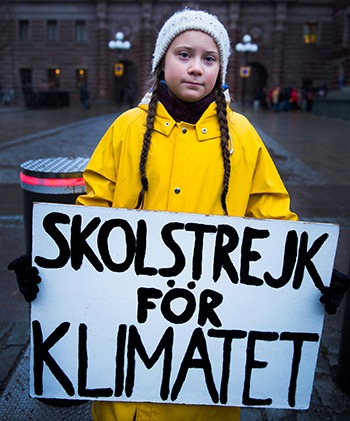 Thunberg cầm biểu ngữ "Nghỉ học vì môi trường" bên ngoài quốc hội Thụy Điển tháng 11/2018. Ảnh: Reuters.