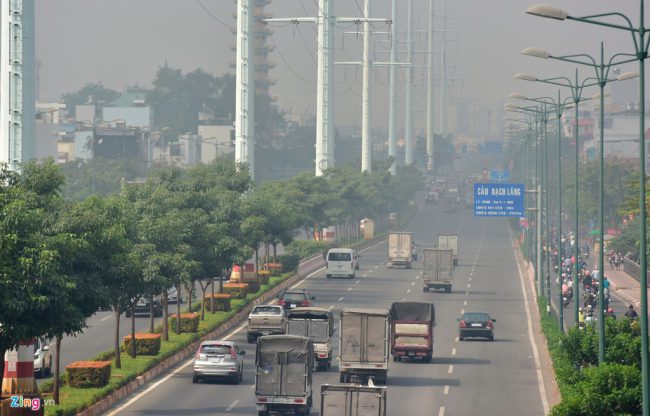 Người dân đi làm trong sương mù bủa vây, hạn chế tầm nhìn vào sáng nay tại đại lộ Phạm Văn Đồng. Ảnh: Lê Quân.