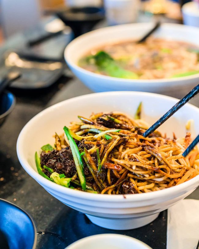 Zhajiangmian là món ăn được làm từ những sợi mì tươi luộc chín để ráo nước, trộn với nước sốt làm từ thịt lợn băm và tương đậu nành rồi thêm ít dưa chuột, giá đỗ và cà rốt thái sợi. Khi thưởng thức, thực khách chỉ việc trộn đều các nguyên liệu trên lại với nhau là được. Món mì này có nguồn gốc từ tỉnh Sơn Đông, Trung Quốc. Ảnh: Circle_by_yuuki, happy_tummiez.