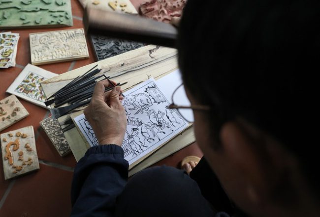 Tranh Đông Hồ in trên ván gỗ, mỗi ván gỗ tương ứng với một màu. Để gõ mộc bản, ông Quả tự tay chọn những tấm gỗ thị dẻo dai, trồng lâu năm, sờ mịn và mát nhất để những nét khắc nhỏ không bị gồ ghề, xước lệch.