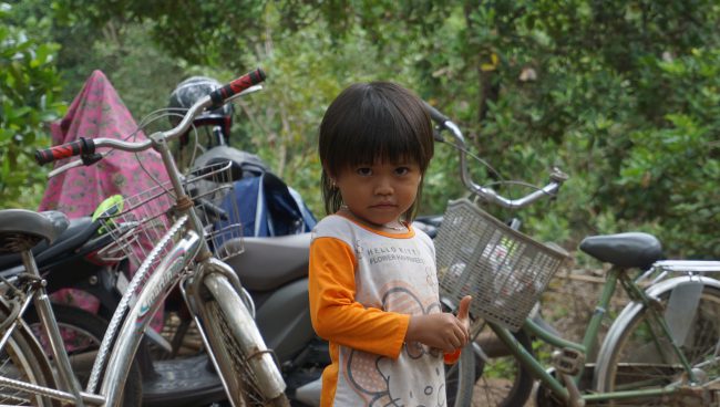 Em bé Bù Ka - Bình Phước Cô bé với đôi mắt tròn xoe đang ngại ngùng nhìn về phía ống kính.