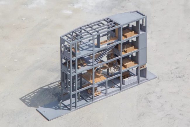 Ý tưởng ban đầu của nhóm thiết kế là tạo một ngôi nhà gỗ (với sàn gỗ cùng các đồ nội thất gỗ) trong một khung bê tông, có hình thức một trệt ba lầu.