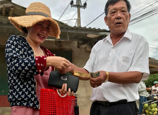 Người dân đi chợ cầm theo làn nhựa được ông Triêm trực tiếp tặng tiền ẢNH: P.T.H