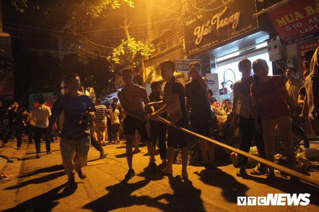 Người dân hỗ trợ lực lượng chức năng nối những ống nước từ xe cứu hỏa đến hiện trường vụ cháy.