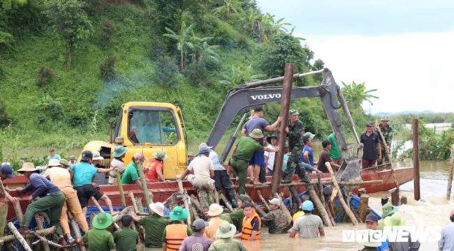 Hàng trăm người ngâm mình dưới nước để gia cố đê tạm.