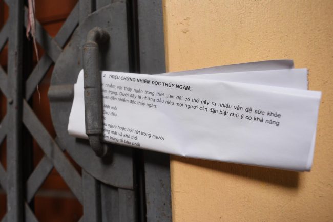 Tờ rơi vẫn cài ở đó nhiều ngày sau khi hộ dân đã chuyển đi do một cơ sở y tế phát đến từng nhà quanh khu vực hỏa hoạn, có nội dung tuyên truyền cách phòng chống nhiễm độc thủy ngân.