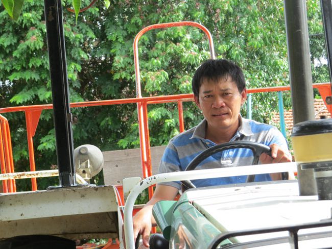 Ông Huỳnh Khắc Vũ lái máy cày đi làm trang trại Ảnh: Bích Đào