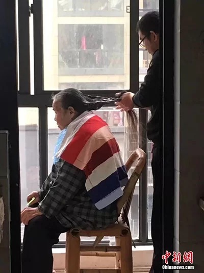 Hình ảnh anh Xu chăm sóc tóc cho mẹ hiện được chia sẻ nhiều trên mạng xã hội ở Trung Quốc. Ảnh: China News.