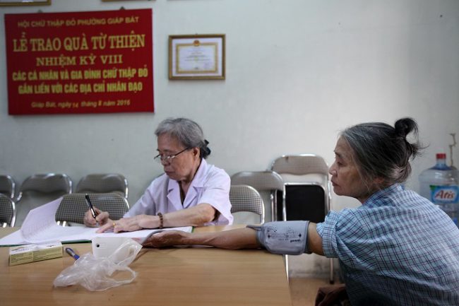 Y tá đo huyết áp cho bệnh nhân trước khi chuyển sang bác sĩ kiểm tra, khám bệnh.