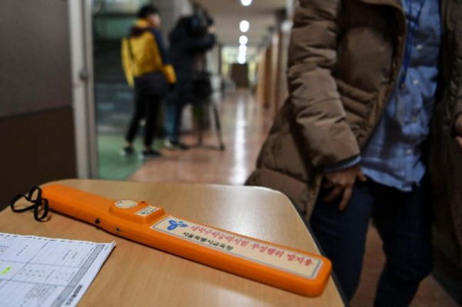 Các thí sinh đều được kiểm tra an ninh trước khi vào phòng làm bài. Điểm thi trường Trung học nữ sinh Ewha sử dụng máy dò kim loại di động, nhằm phát hiện các thiết bị điện tử, tránh trường hợp gian lận trong thi cử. Ảnh: Yonhap.