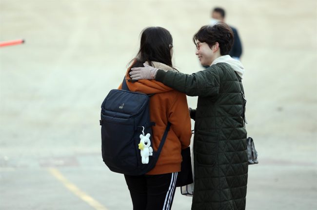 Nhiều phụ huynh đến trường thi cổ vũ, động viên tinh thần sĩ tử trước khi bước vào kỳ thi. Các giáo viên cũng có mặt ở trường từ sớm, trao cho học sinh những cái ôm, gửi đến các em lời chúc tốt đẹp. CSAT được đánh giá là một trong những kỳ thi đại học khốc liệt nhất châu Á. Theo SCMP, khoảng 2% thí sinh thi đỗ vào 3 trường đại học top đầu cả nước. Ảnh: Yonhap, Newsis.