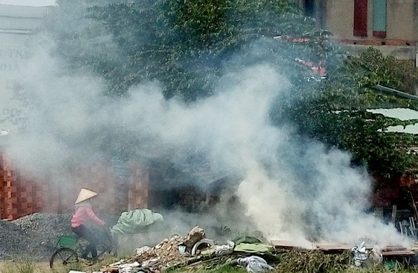 Người dân đốt rác khói bay mịt mù trên đường Nguyễn Văn Linh (P.Tân Thuận Tây, Q.7, TP.HCM). Việc đốt rác bừa bãi như thế này vừa ô nhiễm vừa dễ xảy ra hỏa hoạn - Ảnh: THIÊN THẢO