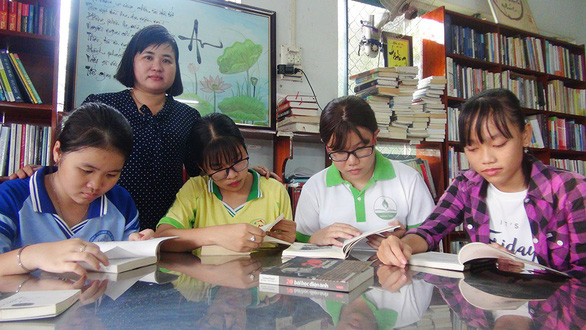 Chị Hằng bên các em học sinh đang đọc sách tại nhà mình