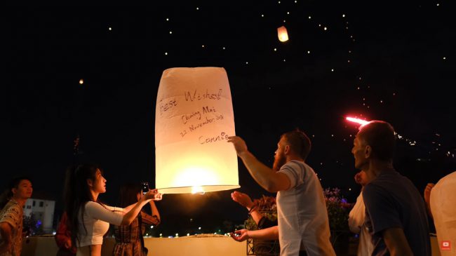 Một du khách nước ngoài được người địa phương chỉ cách thả đèn trời - Ảnh chụp màn hình