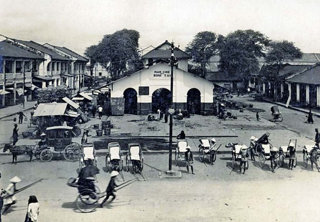 Chợ Bình Tây cũ xây khoảng thập niên 1880, góc Quai de Mytho (nay là đại lộ Võ Văn Kiệt) và đường Bình Tây. Nguồn: flickr manhhai. Bức ảnh này được chụp từ trên cầu Bình Tây bắc qua kinh Tàu Hủ.