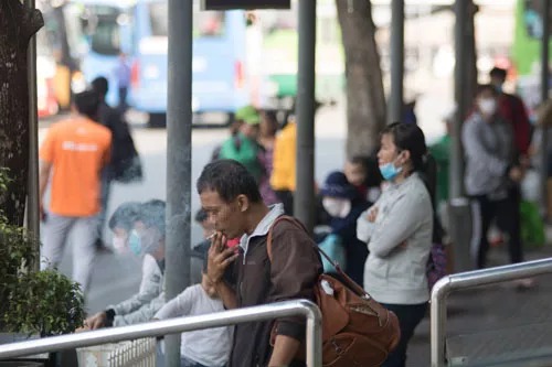 Người đàn ông này vô tư hút thuốc lá ở Bến xe Miền Đông (quận Bình Thạnh, TP HCM) sáng 26-12, trong khi xung quanh có trẻ em Ảnh: GIA MINH