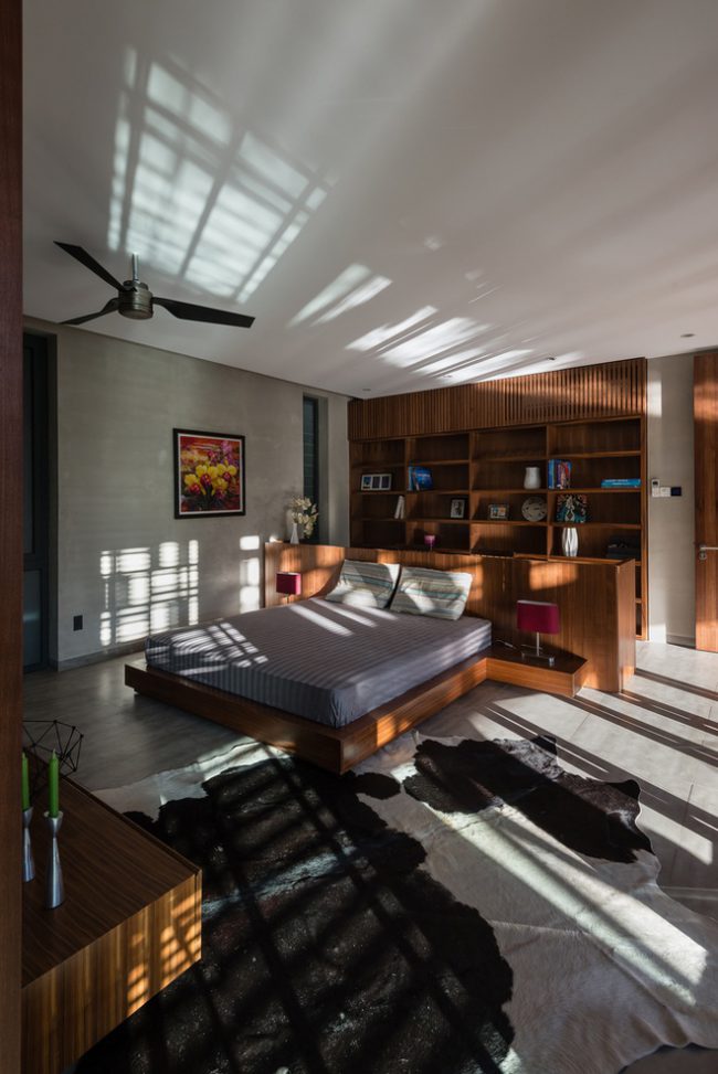 Phòng ngủ có đầu giường không kê sát tường, mà tách ra làm một hệ tủ đầu giường riêng.