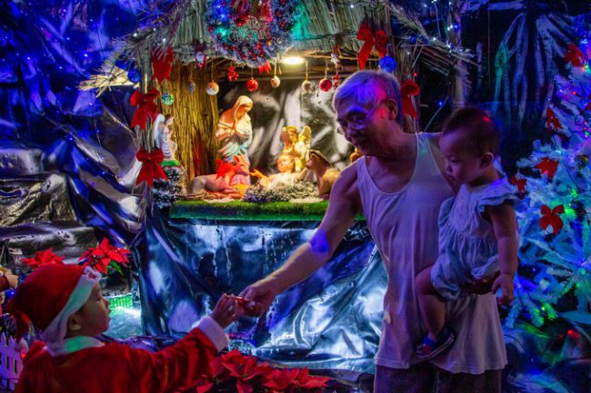 "Mỗi hang đá đều có treo một túi, người lớn trong xóm có kẹo gì thì bỏ vào, đến tối lấy ra cho đám trẻ đến xem hang đá", ông Phí nói, vừa lấy một chiếc kẹo từ hang đá để đưa cho cháu nhỏ.