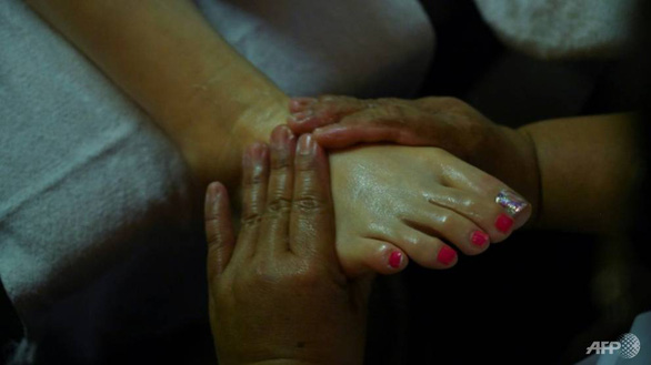 Sau khi đi mua sắm, du khách có thể ngồi nghỉ mệt kết hợp massage chân, hình ảnh rất phổ biến ở các chợ, siêu thị, trung tâm mua sắm ở Thái Lan - Ảnh: AFP