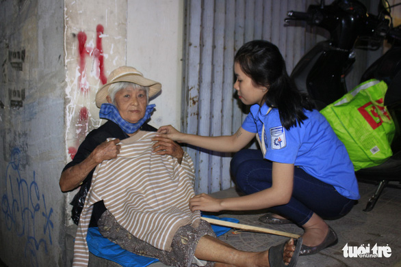 Bà Lê Thị Phúc Hà (78 tuổi) ướm thử chiếc áo mới do nhóm sinh viên tình nguyện trao tặng