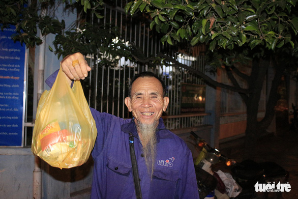 Ông Nguyễn Đọc (65 tuổi, quê Phú Yên) khoe những chiếc bánh, hộp sữa được nhận hôm nay sẽ gửi về nhà làm quà cho vợ và cháu