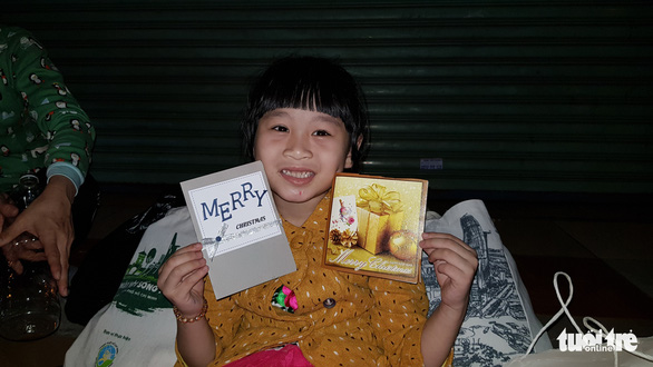 Bé Nhi tươi cùng món quà đặc biệt là hai tấm thiệp mừng Giáng sinh