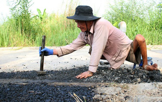 Sau hơn bốn năm vá đường bằng xi măng, mới đây ông Dân phát hiện ra có thể tận dụng những cục nhựa đường cũ để miếng vá chắc và đẹp hơn. Ảnh: Diệp Phan.